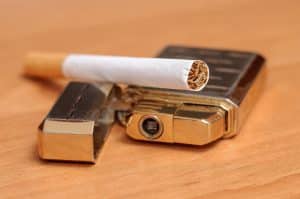 Zigarette und goldenes Feuerzeug