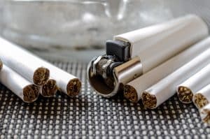 Weißes Feuerzeug mit Zigaretten und Aschenbecher