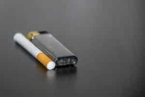 Zigarette und Feuerzeug auf Tisch